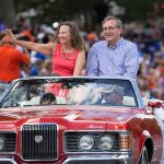 president kent fuchs and his wife in convertible in homecoming parade